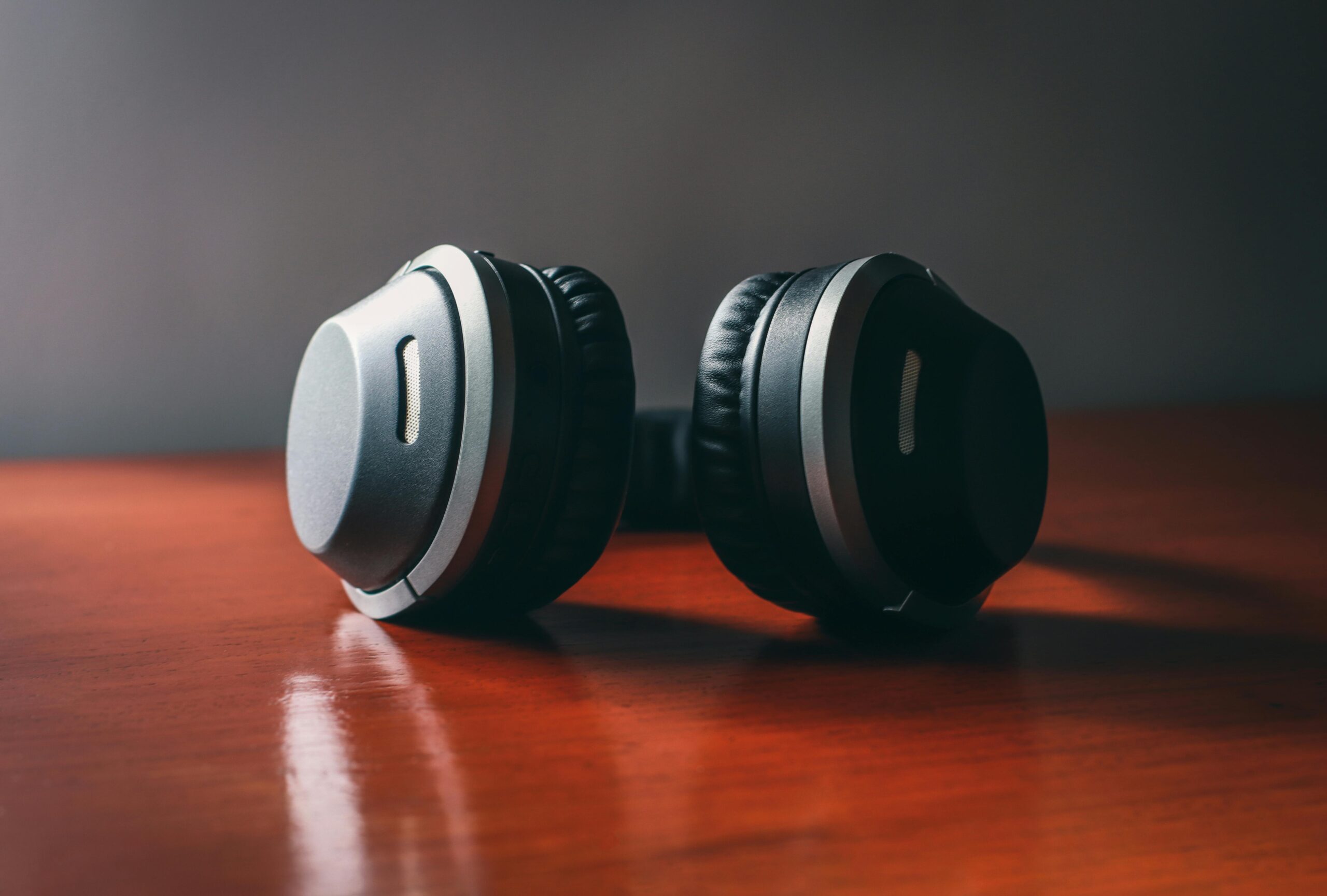 Close-up of sleek wireless headphones on a wooden surface, perfect for music enthusiasts.